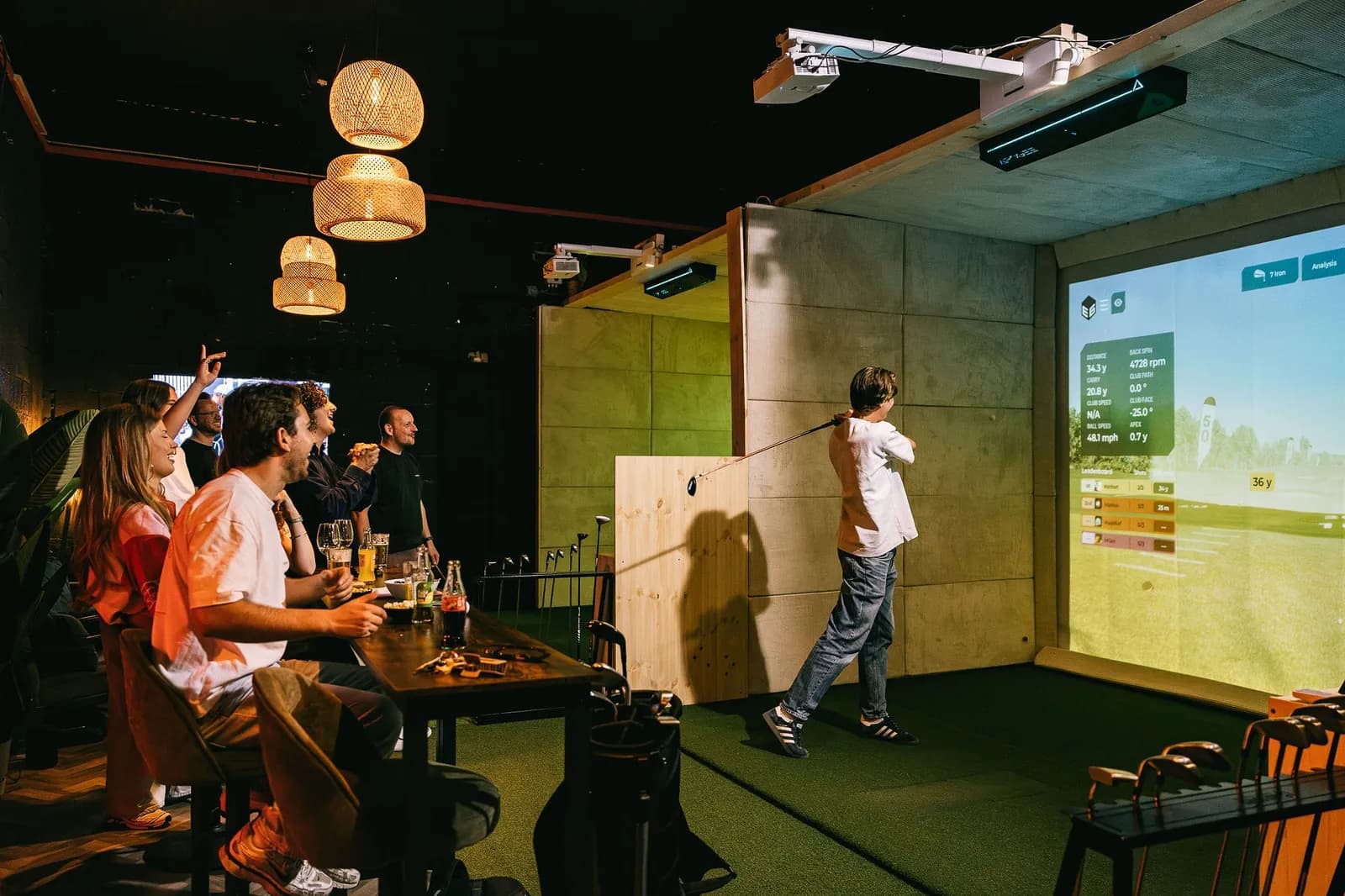 Vrienden aan tafel naast een simulator bij Foreplay