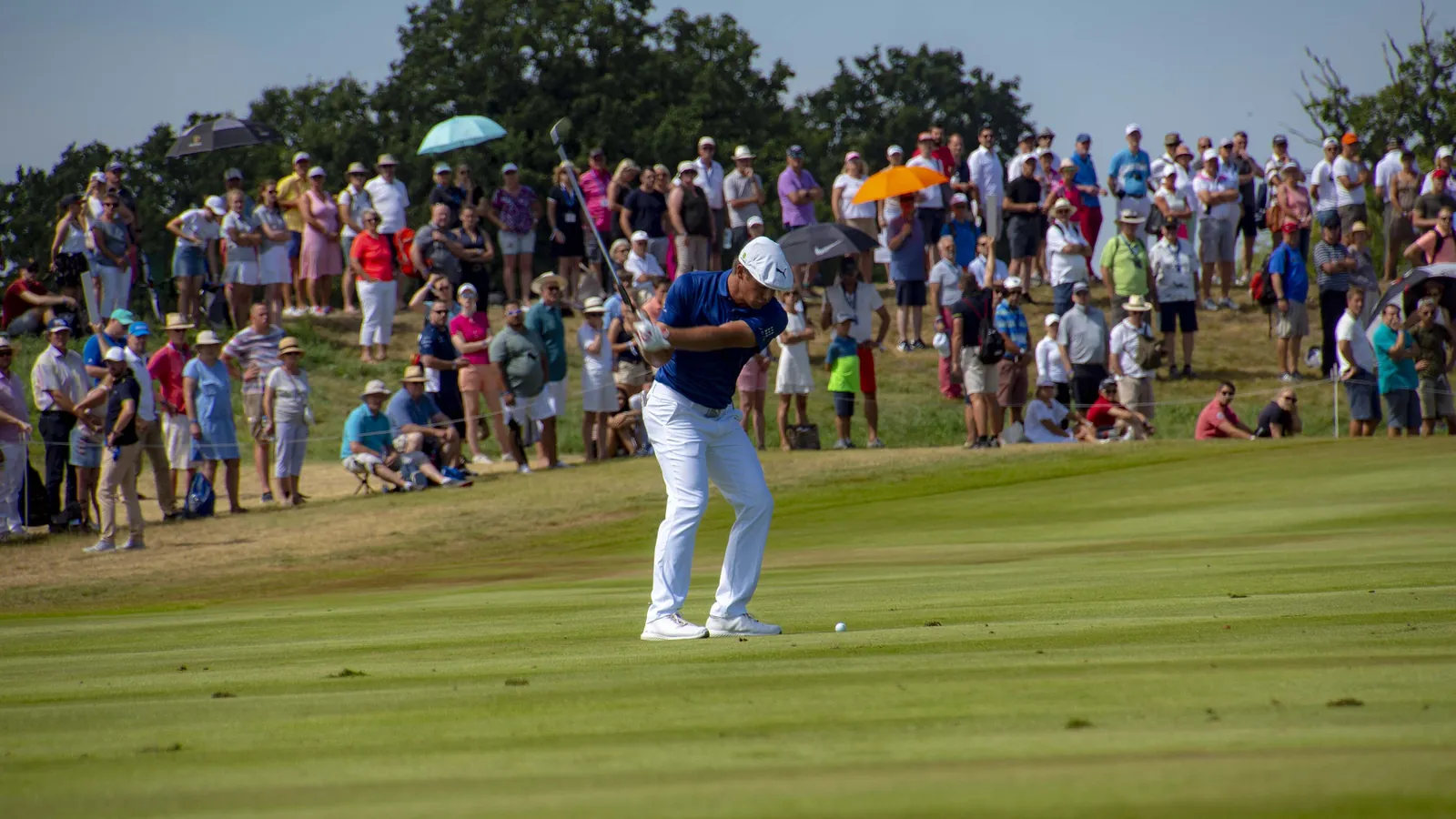 Bryson DeChambeau hits an approach shot in front of a large crowd at the 2018 European Open