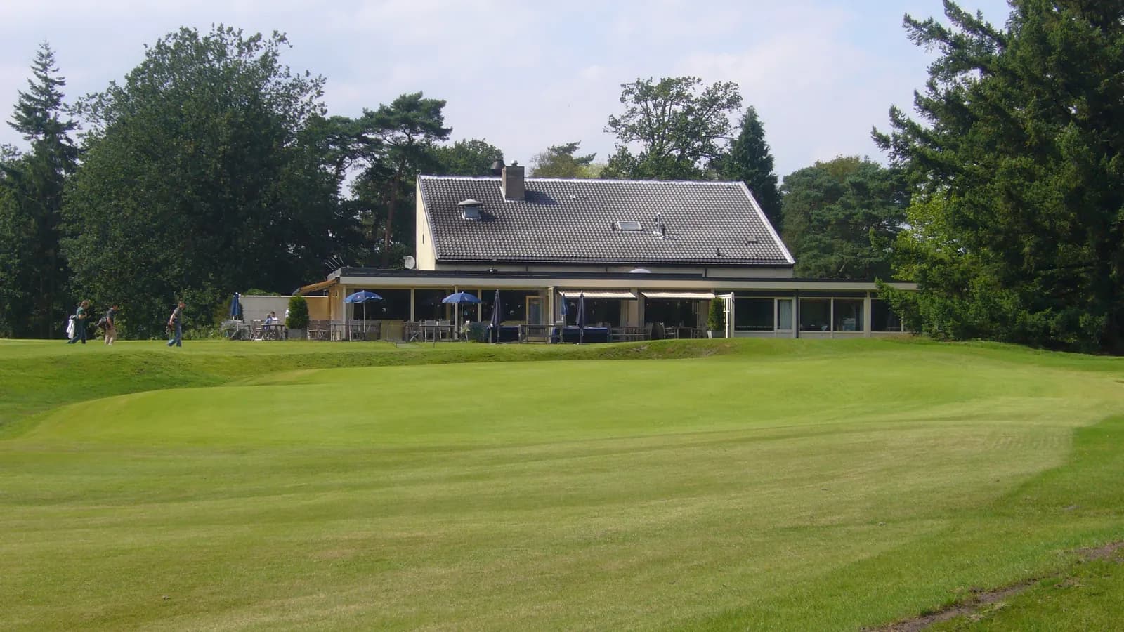 The 18th green at the Hilversumsche Golf Club with the clubhouse behind it
